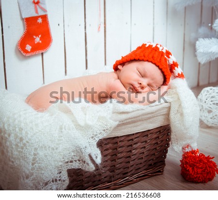 Cute newborn baby sleeps in a santa claus hat close-up