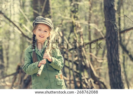 little cute girl near her hut in the forest close-up. Photo in retro style