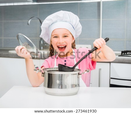little girl in a cap chef prepares soup