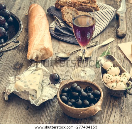French cuisine. Different types of cheese, wine and other ingredients on a wooden table