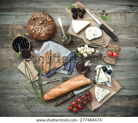 French food on a wooden background. Different types of cheese, wine and other ingredients on a wooden table