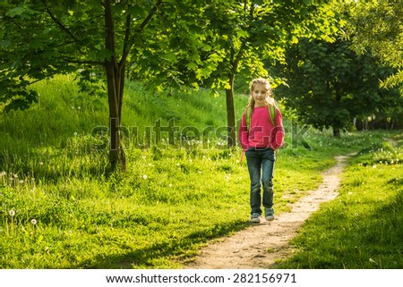 happy little girl go to school through the forest