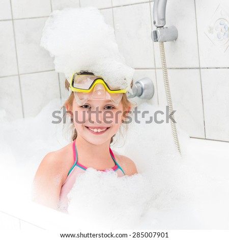 girl in sunglasses dive with the tube in the bath with foam