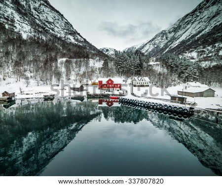 journey through fjord. red house on a background of the rocky mountains