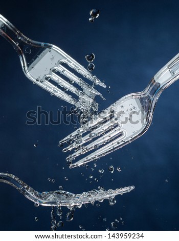 Rinsing Plastic Forks / Washing / Time is stopped in this high speed photograph. Washing or reusing plastic forks. Environmentally friendly.