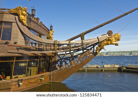 St. Petersburg, Russia, sculptures on sailing ship and Winter palace (Hermitage museum) on bank of river Neva.