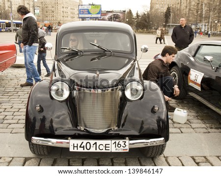 MOSCOW - APRIL 21: Russian retro car Moskvich on rally of classical cars on Poklonnaya hill,  April 21, 2013, in town Moscow, Russia, unidentified people looking at rally and inside the car.