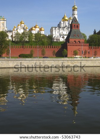 Moscow, Kremlin fortress with cathedrals inside on bank of Moscow-river, reflection in water.