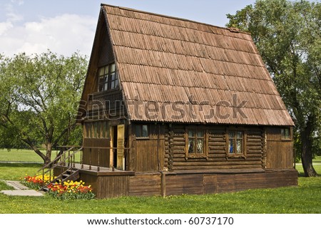 Wooden house and trees around, summer. Recorded in national park Kolomenskoye in Moscow. Traditional type of village houses in Russia.