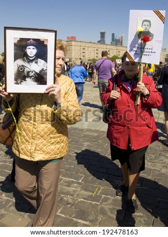 MOSCOW - MAY 9, 2014: Holiday Victory Day devoted to victory in Second World War, people with photoraphs of war veterans on the street.