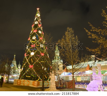 MOSCOW - DECEMBER 19, 2013: Christmas tree and ice sculptures on Red square, St. Basils Intercession cathedral and Spasskaya tower of Kremlin.