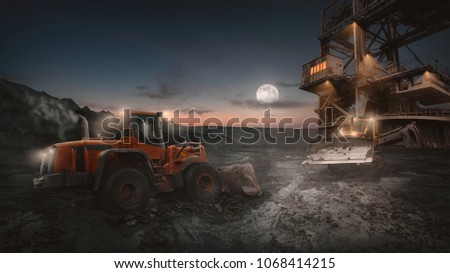 Heavy equipment vehicles of various types - wheeled bulldozer -  in night shift work on a construction site at open pit mine.