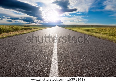 Driving on an empty road to the sun