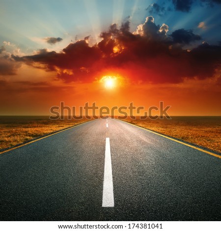 Driving On An Empty Highway Against The Setting Sun
