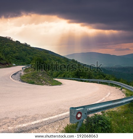 Road with a sharp bend in the forest on the mountain