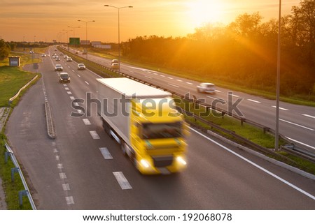 Yellow truck in the rush hour on the highway at dusk
