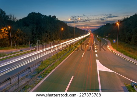 Long exposure photo on a highway with light trails at dusk