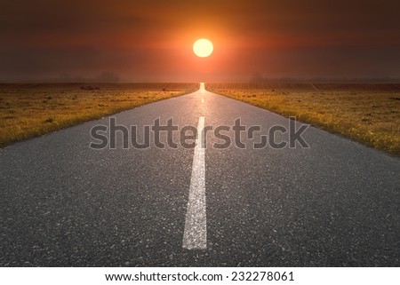 Empty open road towards the sun at sunset. Freedom concept.