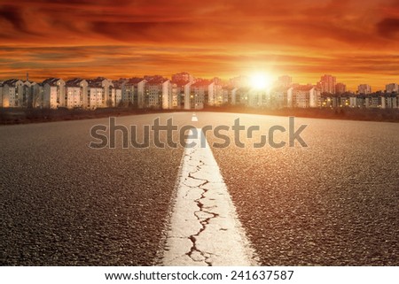 Entry into the city on open asphalt road towards the setting sun