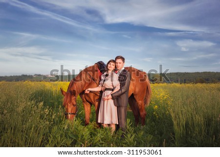 The man being led by the bridle the horse riding girl. Couple in love with a horse in a field with yellow flowers against the sky