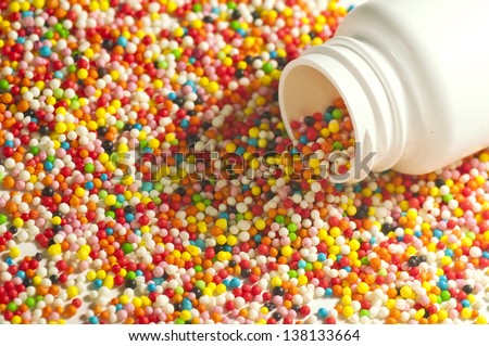 medicine for children - a colorful candy / sweet spilled out of a medical pill box / can / tube