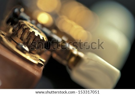 a superb close-up of classic guitar tuning mechanism / pegs / wheels / cog-wheels