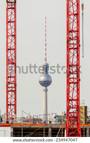 Germany, Berlin - TV Tower seen through two big building cranes.