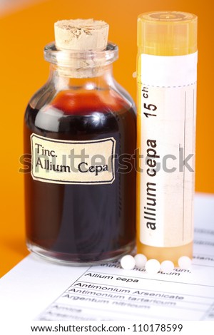 Allium Cepa plant extract. Mother tincture and homeopathic pills on sheet