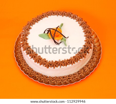 White cake with toffee stars decoration on orange background