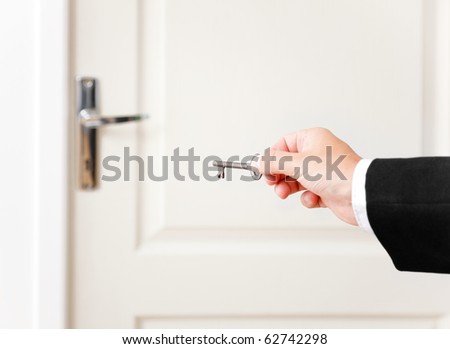 Hand holding the key of door. Metaphoric view of a key to a solution