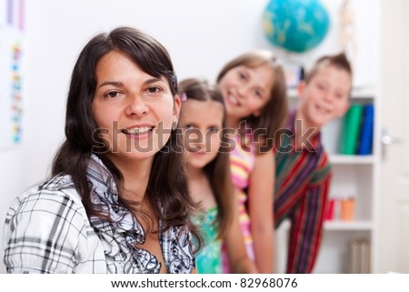 Cheerful teacher in front, several students in back