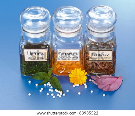 Various plant extract in bottles, Urtica Urens, Calendula Officinalis, Echinacea Angustifolia and homeopathic medication pills in front