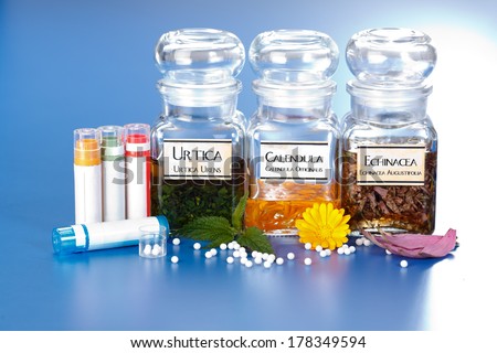 Various plant extract in bottles, Urtica Urens, Calendula Officinalis, Echinacea Angustifolia and homeopathic medication pills in front