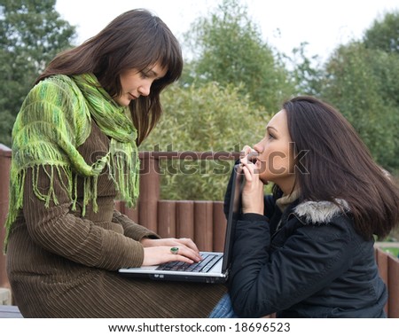 Two students studying outdoor with laptop before exam