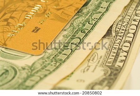 Gold credit card on dollar bank notes. Financial background. Shallow DOF