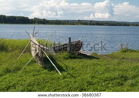 Old wooden boat and fishing net on Onega lake. North Russia