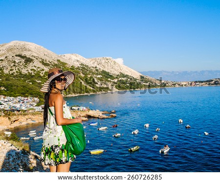 Asian woman standing and smiling by the beautiful sea and blue sky on island in summertime