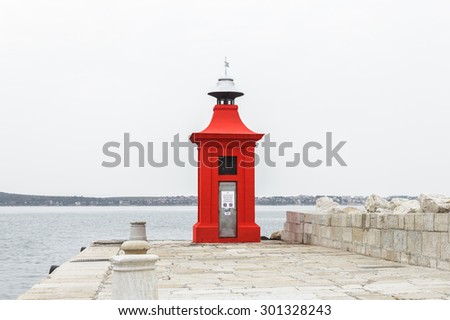 Red lighthouse at port of Piran on a cloudy day, Slovenia ( sign on door means \