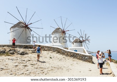 MYKONOS, GREECE- JUNE 16: Many tourists visiting the famous tourist spot of windmills on island Mykonos, Greece on June 16,2015. Windmills from the 16th century, landmarks of Mykonos.