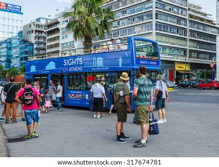 ATHENS, GREECE- JUNE 12: Tourists on hop on- hop off tourist bus for sightseeing in Athens, Greece on June 12, 2015.