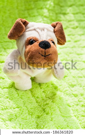 Plush puppy on green blanket.