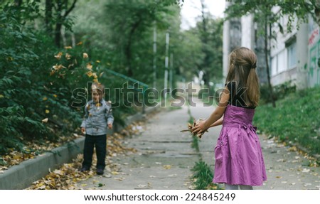 Happy children throwing leaves and play outdoor... Selective focus
