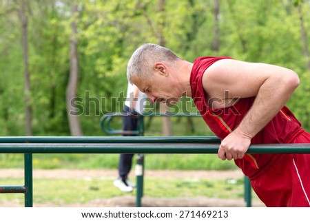 Senior Exercising In Sport Park