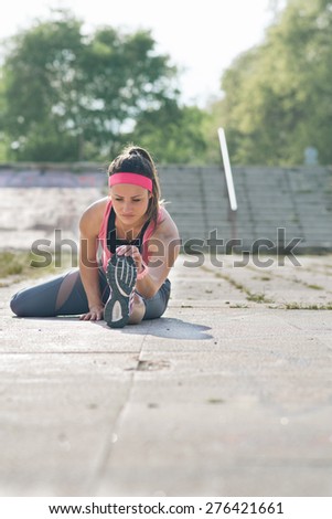 Woman doing  warm-up exercises before running.Photo is carefully post processed to mach old Kodak  film look. Soft focus, shallow depth of field.