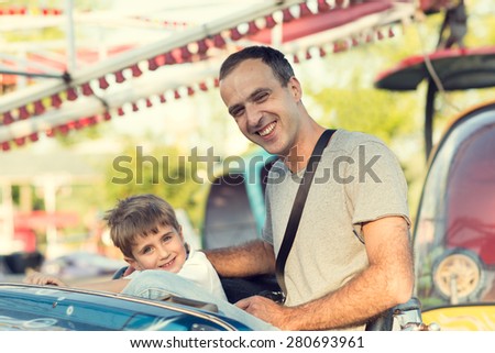 Son and father in the amusement park.