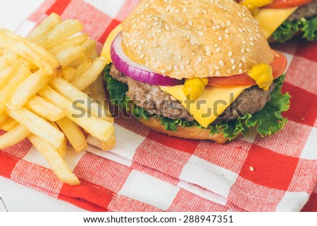 American beef burgers with cheese on the white wooden table. Selective focus and small depth of field.