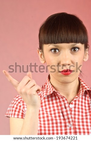Pretty pin-up brunette woman in checkered shirt threatens