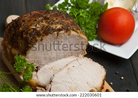 Slow roasted pork loin lying on wooden table
