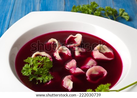 Traditional polish clear red borscht with dumplings with mushrooms