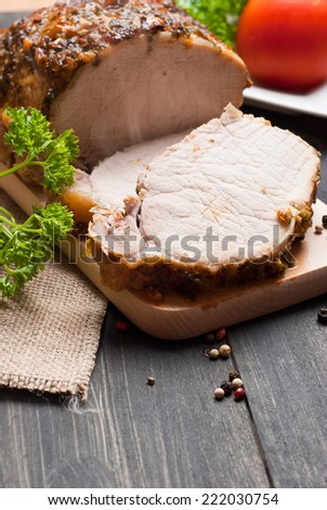 Slow roasted pork loin lying on wooden table